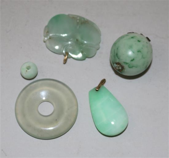 A group of four Chinese jadeite pendants or beads and a similar hardstone disc, late 19th/20th century, largest 3.3cm